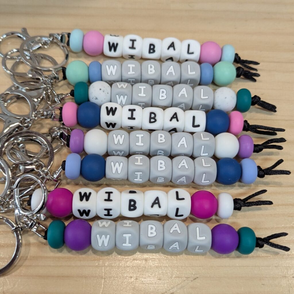 Eight multicoloured beaded keychains with the acronym WIBAL